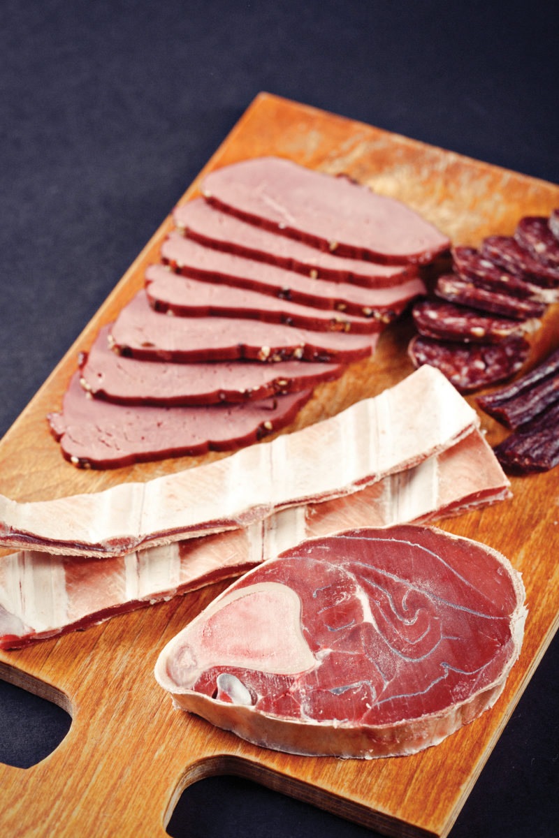 deer meat and sausage on cutting board