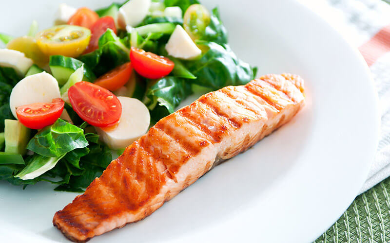 Fish filet and fresh vegetables that are part of the paleo diet plan